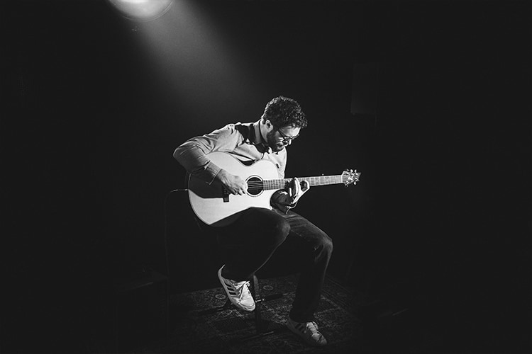 how to hold a guitar sitting